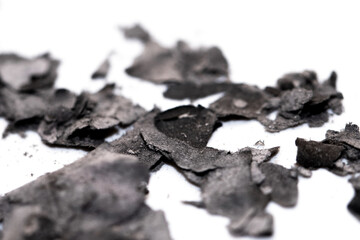 Scattered burnt ashes and debris on a white background