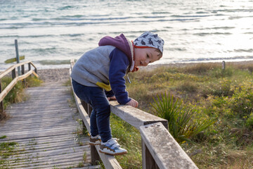 Kleinkind spielt am Strandzugang auf Mallorca