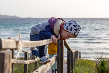 Kleinkind spielt am Strandzugang auf Mallorca