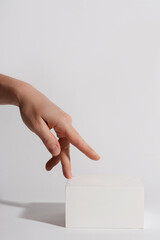 Female hand and luxury white block pedestal for product showcase
