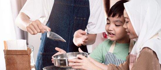 Muslim father and children bonding in the kitchen, learning to bake together, sharing joy, love, and tradition while creating sweet treats in a warm and happy home environment