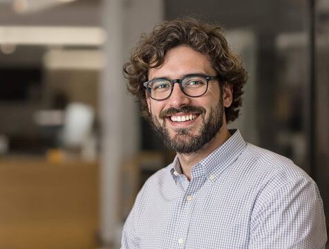 Portrait en gros plan d&rsquo;un jeune homme souriant, homme d&rsquo;affaires souriant et regardant la cam&eacute;ra, financier ou investisseur travaillant dans un bureau, satisfait des r&eacute;sultats obtenus.