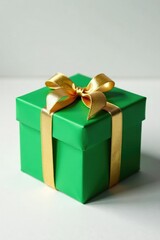 Fototapeta premium Delicate golden ribbon wrapped around a green Christmas gift box on a white background, festive decoration, green christmas gift box