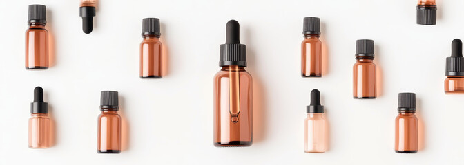 Obraz premium Collection of amber dropper bottles for essential oils on a white background
