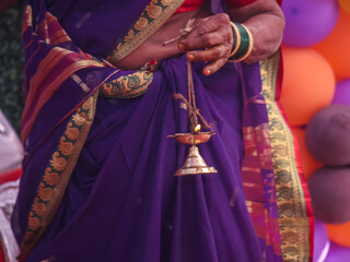 The brass hanging oil lamp is the hand of an Indian woman.