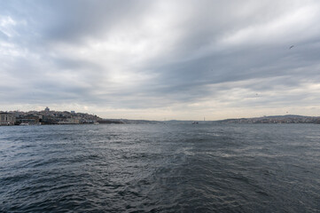 Panorama view from the deck of the ferry to Bosphorus, Istanbul, Turkey. Seascape near the Uskudar pier. Cloudy day and seagulls.
