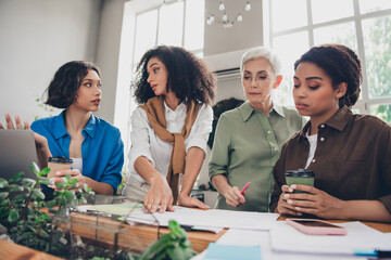 Photo of four diverse women businessladies feminists community discuss startup comfortable modern office room interior indoors workspace