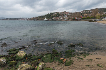 Beykoz district coastline view in Istanbul, Turkey. Cloudy day, seagulls and ferry.