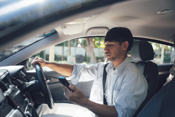 Distracted Driving Danger: A close-up shot of a man using his mobile phone while driving,...