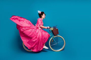 Full length photo of happy attractive lady dressed baroque costume driving cycle copy space isolated blue color background