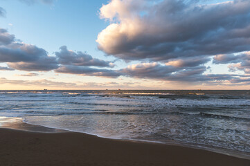Stunning sunset view of Kumkoy beach. Black sea, amazing sky and boats in the distance. Turkey, Kumköy