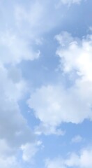 Obraz premium JSky with fluffy white clouds, light blue atmosphere, serene calm weather, wispy cloud formations, soft lighting, ethereal peaceful scene, minimalist beauty