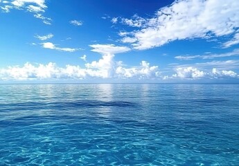 Obraz premium A vast expanse of blue ocean, with clear skies and clouds in the background.