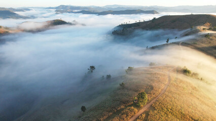 Aerial landscape view of the sea of fog flowing on hills and campsite