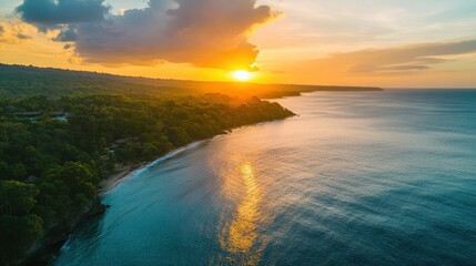 Obraz premium A picturesque drone shot of a tropical sea at sunset, the warm hues reflecting off the water, creating a magical contrast with the lush, green coastline