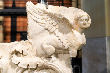 Detail of ancient marble sculpture representing a winged sphinx