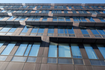 Gennevilliers, France - 01 13 2025: View of a Glass facade of a building and reflections of the sun backlit on the windows and on the road.