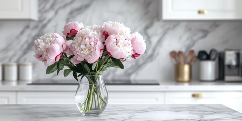 Two vases of pink flowers sitting on a marble countertop, creating a warm and inviting kitchen atmosphere.