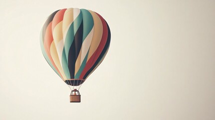 A vibrant hot air balloon featuring a colorful striped design floating gracefully against a pale sky.