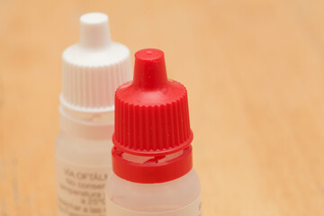 small plastic eyedrop dispenser bottles with different colors of cup