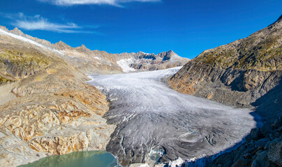 High mountain glacier Rhonegletscher and glacial lake on Furkapass in summer Switzerland