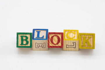 Wooden blocks spell out the word  "BLOCK" with shadow isolated on white background