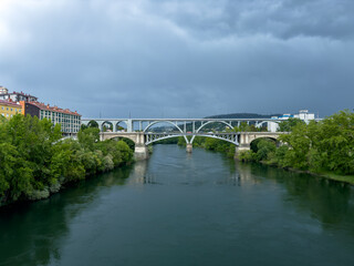 Arched Bridge Spanning a River Under Dramatic Skies