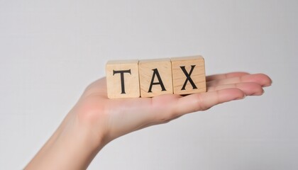 Hand Holding Wooden Blocks with Letters TAX for Financial Concept