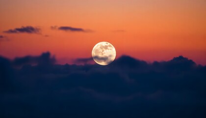 Full Moon rising above the clouds during sunset creating stunning twilight colors
