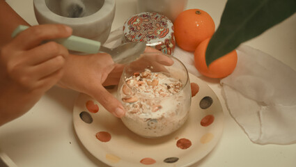 Eating overnight oat with nuts and raisins in a cozy springtime breakfast setup showing a relaxing...