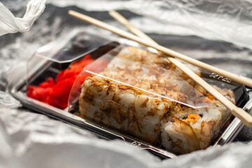 Sushi roll set in take away package in delivery bag. Food delivery concept. Food in plastic packaging