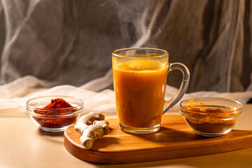 Steaming cup of herbal tea on wooden tray. Cozy atmosphere for winter evening. Concept of relax and didgital detox at home