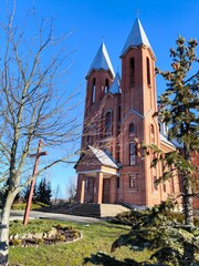 Red brick Catholic church in autumn.