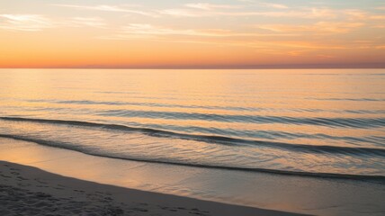 Fototapeta premium Tranquil beach scene at sunset with gentle waves lapping the shore, creating a serene atmosphere infused with warm colors.