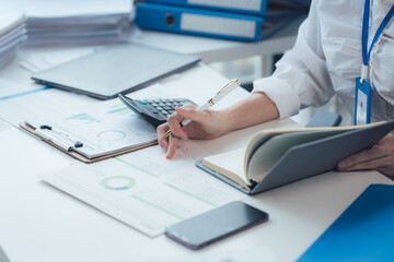 Focused Professional: Close-up of a person's hands meticulously taking notes in a notebook,...