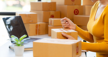 E-commerce Packing: A close-up shot of a person's hands meticulously sealing a cardboard box,...