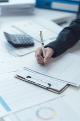Close-up of a Hand Writing on a Clipboard: A close-up shot focuses on a hand diligently writing on a clipboard, showcasing meticulous focus and determination.  The scene is filled with paperwork.
