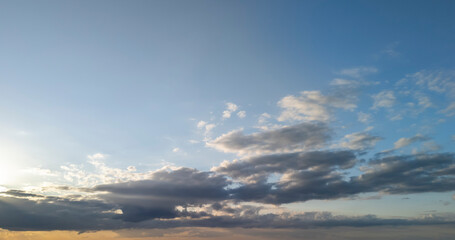 Obraz premium A serene sky at sunset, displaying soft clouds and a gradient of warm colors. Perfect for nature-themed projects and calm atmospheres.