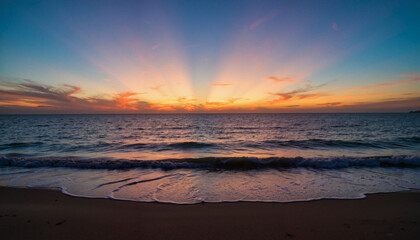 Fototapeta premium Twilight over serene ocean shore at sunset, peaceful reflection
