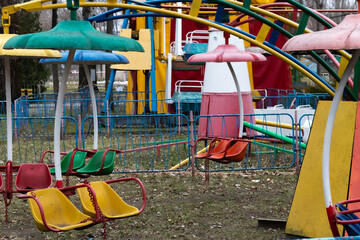 Old amusement park in autumn with faded attractions. Ideal for themes of decay, urban exploration, and the haunting beauty of forgotten places.