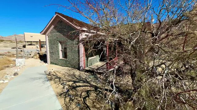 Unique architectural curiosity showcases a historic bottle house in the eerie Rhyolite ghost town near Death Valley, exemplifying innovative frontier resourcefulness and preserving a glimpse of early 