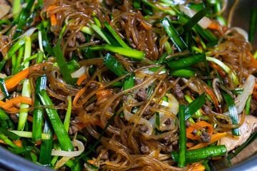 mixing Japchae ingredients in the bowl