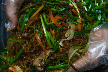 mixing Japchae ingredients in the bowl