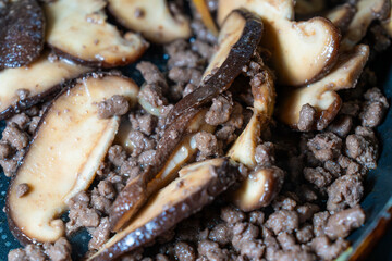 stir-frying the seasoned beef and shiitake mushroom