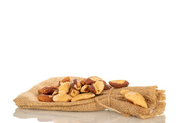 Brazil nuts without shells with jute bag, macro, isolated on white background.