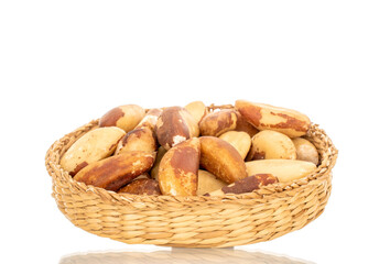 Brazil nuts without shells with straw plate, macro, isolated on white background.