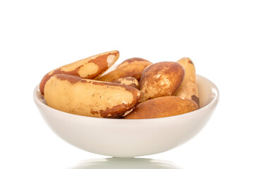 Brazil nuts without shells with ceramic saucer, macro, isolated on white background.