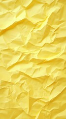 Crumpled yellow paper forming a textured and abstract background, offering a vibrant and unique surface ideal for diverse design and artistic projects. Perfect for creative endeavors