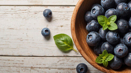 Blueberries, Fresh blueberries in wooden bowl on wooden table, Close-up of Blueberries with basil in wooden bowl, Blueberries on Table Background