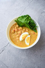homemade meal of chickpeas with curry and egg. neutral background
